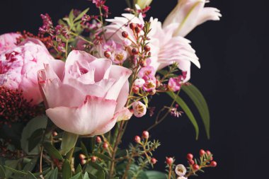 Siyah arka planda farklı çiçeklerden oluşan güzel bir buket, yakın plan. Çiçek kart tasarımı koyu renkli efekt