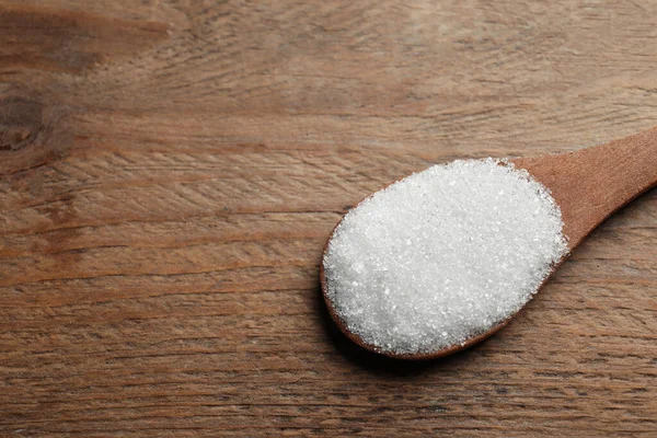 Cuchara de azúcar blanca en la mesa de madera, primer plano. Espacio para texto — Foto de Stock