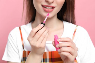 Pembe arka planda ruj izi olan güzellik blogcusu, yakın plan