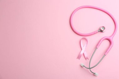 Renkli arka planda pembe kurdele ve steteskop, S ile düz yatıyordu.