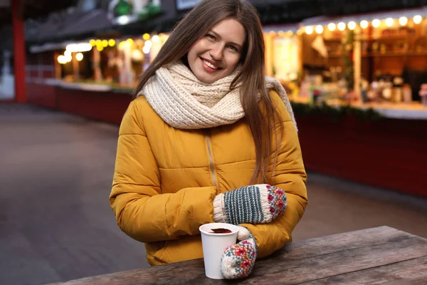 Щаслива жінка з глінтвейном на зимовому ярмарку — стокове фото