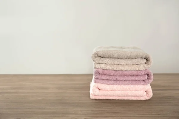 Stack med färska handdukar på grått träbord. Plats för text — Stockfoto