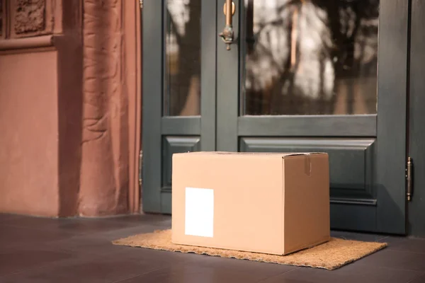 Bezorgd pakket op deurmat bij ingang — Stockfoto
