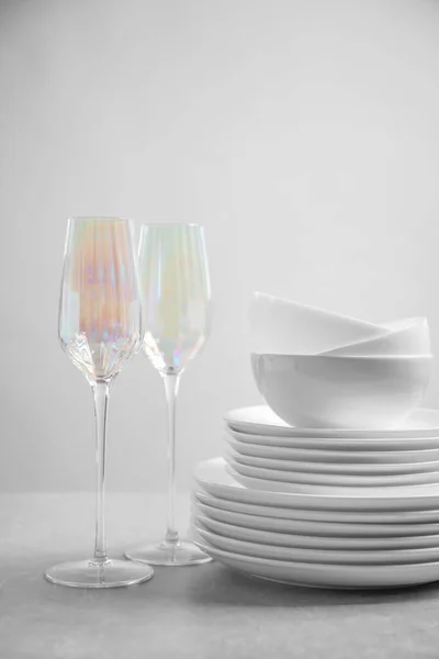 Набір чистих посуду та окулярів на світло-сірому столі — стокове фото