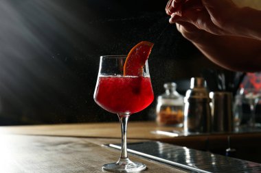 Barmen tezgahta taze alkollü kokteyl hazırlıyor.