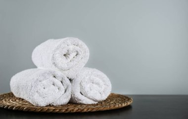 Temiz banyo havluları ve koyu gri masada hasır. Metin için boşluk