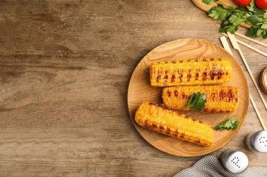 Ahşap masada nefis ızgara mısır koçanları. Metin için boşluk