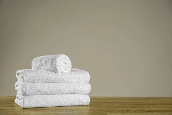 Clean bath towels on wooden table. Space for text