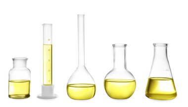 Different laboratory glassware with yellow liquid isolated on wh