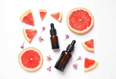 Flat lay composition with bottles of citrus essential oil on white background