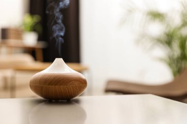 Aroma yağı yayıcı evdeki ışık masasında, mesaj için yer var. Oda spreyi