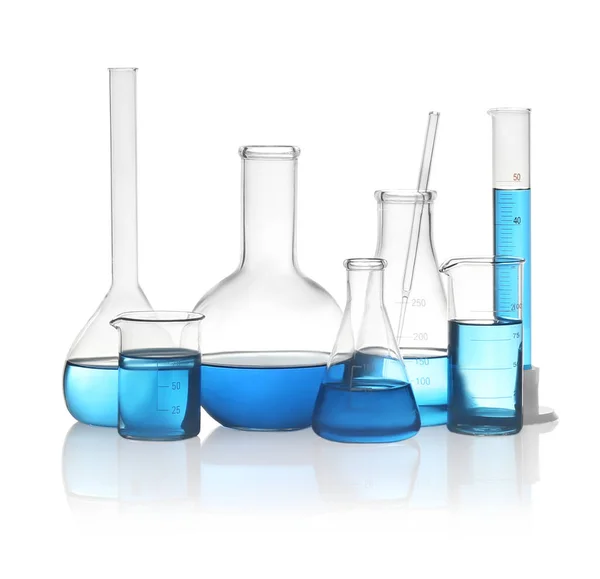 Verschillende laboratoriumglaswerk met lichtblauwe vloeistof geïsoleerd o — Stockfoto