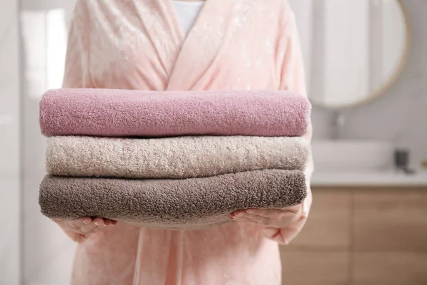 Woman holding fresh towels in bathroom, closeup — Stock Photo, Image