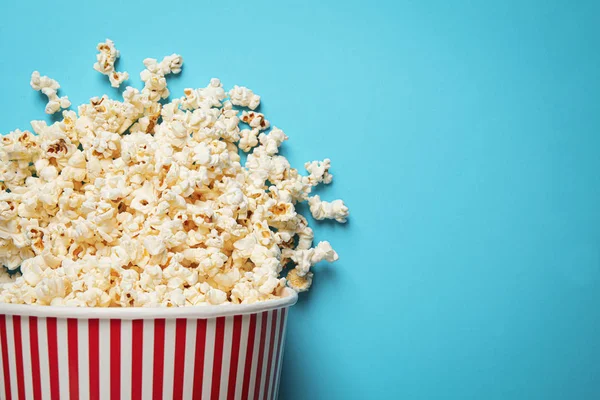 Overturned Paper Bucket Delicious Popcorn Light Blue Background Top View — Stock Photo, Image