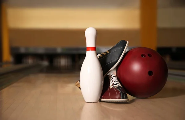 Pin, shoes and ball on alley in bowling club. Space for text