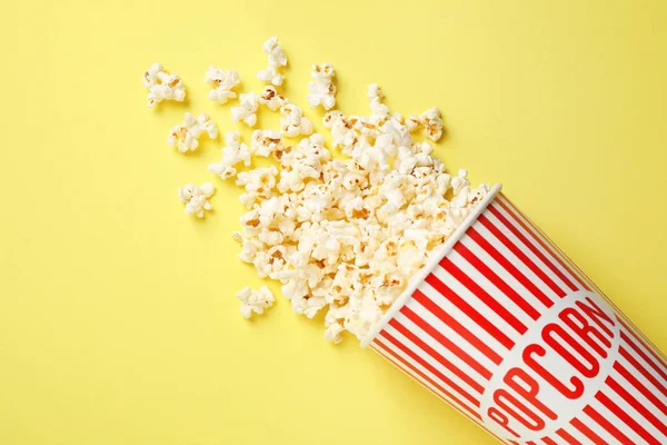 Deliciosas palomitas de maíz sobre fondo amarillo, vista superior — Foto de Stock