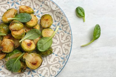 Lezzetli kavrulmuş Brüksel lahanası, beyaz ahşap fesleğenli.