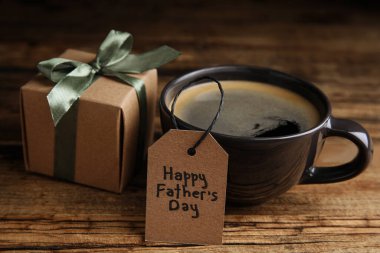 Bir fincan kahve, hediye kutusu ve tabirle tahta masada Babalar Günün kutlu olsun.
