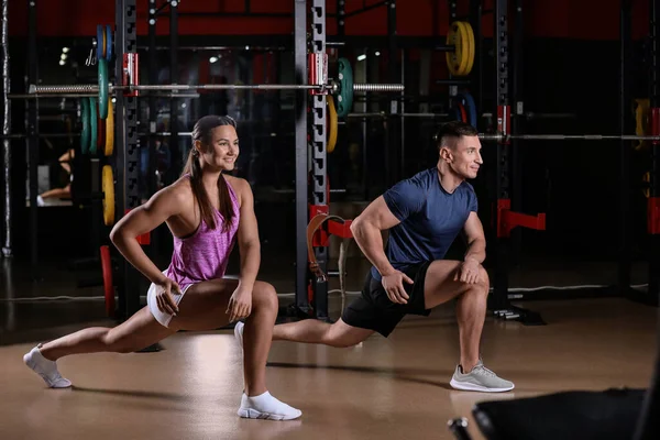 Paar stretching na de training in de moderne fitnessruimte — Stockfoto