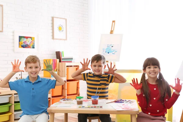Crianças pequenas bonitos com palmas pintadas no quarto — Fotografia de Stock