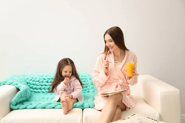 Mère et fille en peignoirs assis sur le canapé — Photo