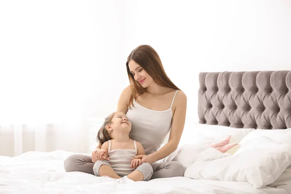 Madre feliz con hija pequeña en el dormitorio — Foto de Stock