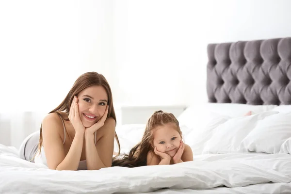 Madre feliz con hija pequeña en el dormitorio — Foto de Stock
