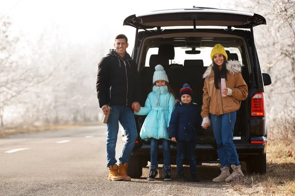 Happy family with little children near modern car on road — 스톡 사진