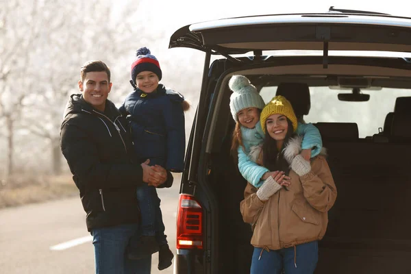 Szczęśliwa rodzina z małymi dziećmi w pobliżu nowoczesnego samochodu na drodze — Zdjęcie stockowe