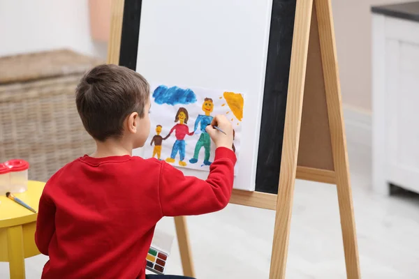 Little child painting on easel in room — ストック写真