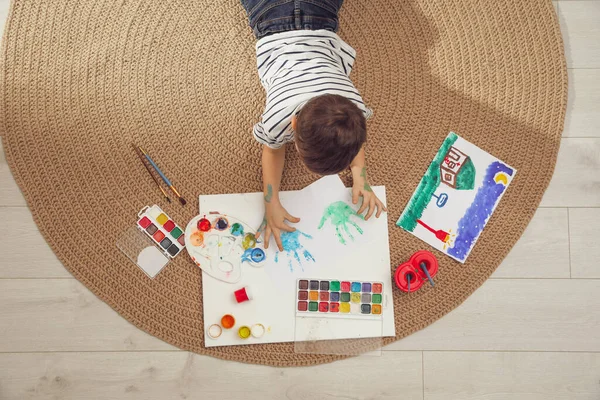 Little child painting on floor at home, top view — Stock Photo, Image