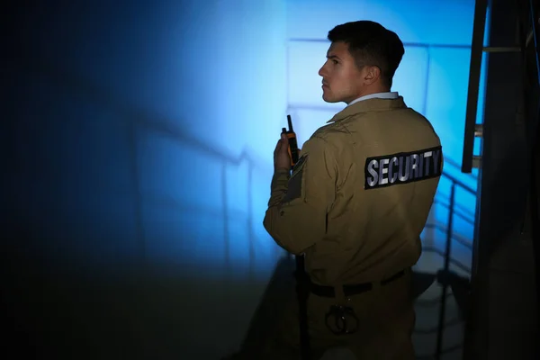 Professional security guard with portable radio set on stairs in — Stock Photo, Image