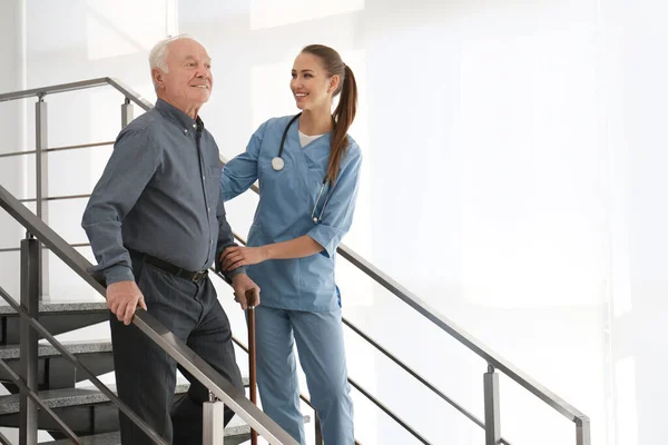 Az orvos segít egy idős betegnek a modern kórházban. — Stock Fotó