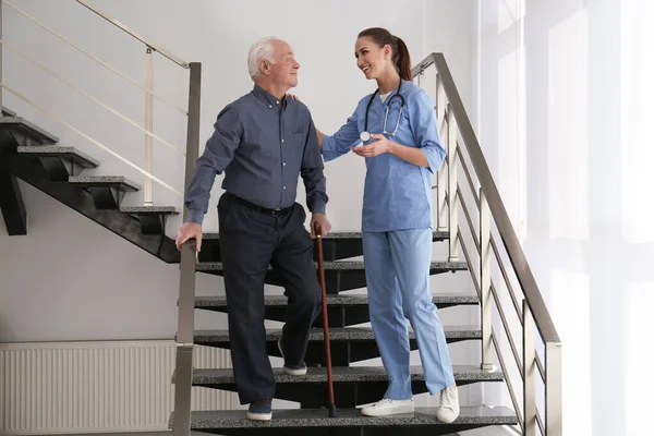 Arts helpt senior patiënt in modern ziekenhuis — Stockfoto