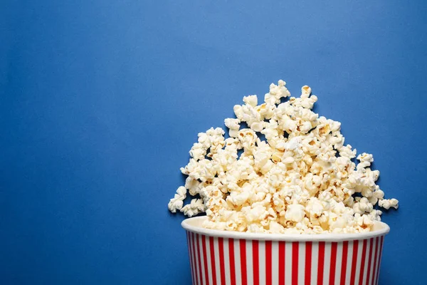 Cubo Papel Volcado Con Deliciosas Palomitas Maíz Sobre Fondo Azul — Foto de Stock