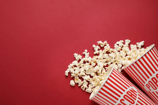 Composición plana con deliciosas palomitas de maíz sobre fondo rojo. S — Foto de Stock