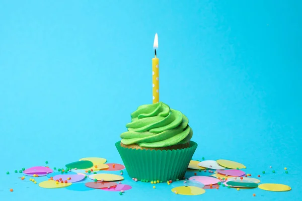 Délicieux cupcake d'anniversaire avec crème verte et bougie brûlante o — Photo