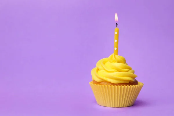 Delicioso cupcake de cumpleaños con crema amarilla y vela encendida —  Fotos de Stock