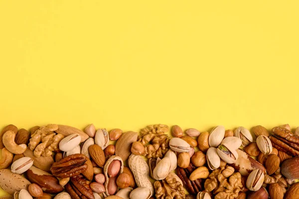 Diferentes Deliciosas Nueces Sobre Fondo Amarillo Planas Espacio Para Texto — Foto de Stock