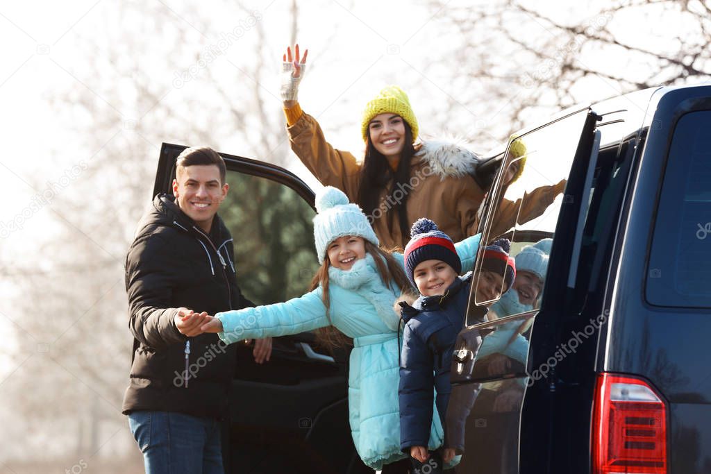 Happy man near modern car with his family outdoors