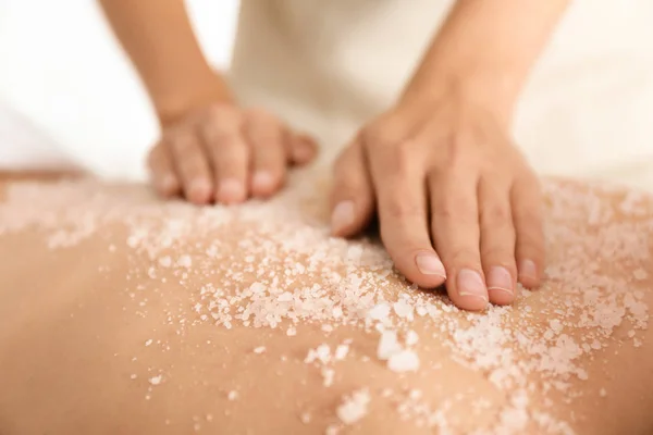 Νεαρή γυναίκα που έχει διαδικασία καθαρισμού του σώματος με θαλασσινό αλάτι σε spa — Φωτογραφία Αρχείου