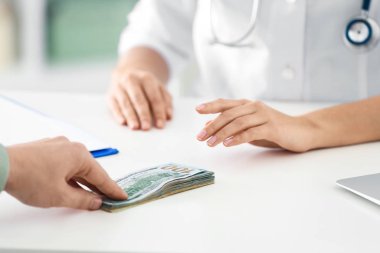 Hasta klinikteki doktora rüşvet veriyor, yakın plan. Yozlaşmış tıp