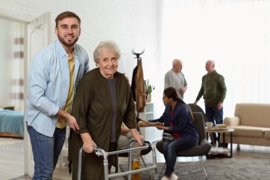 Yaşlı bir kadına yaşlı fahişe Walker 'la yardım eden bakım işçisi.