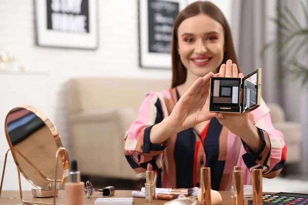 Beauty blogger showing eyeshadow palette at home — Stock Photo, Image