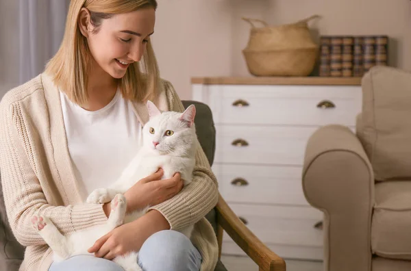 Νεαρή γυναίκα με την όμορφη άσπρη γάτα της στο σπίτι. Χνουδωτό κατοικίδιο — Φωτογραφία Αρχείου
