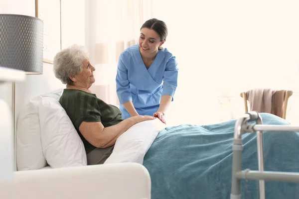 Cuidador con anciana en hospicio geriátrico — Foto de Stock