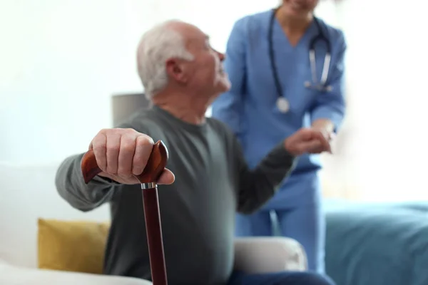 Cuidador ayudando a anciano en hospicio geriátrico, enfoque en h —  Fotos de Stock