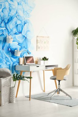 Stylish living room interior with blue flowers painted on wall. 