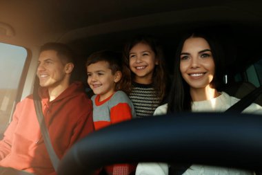 Happy family with little children inside modern car