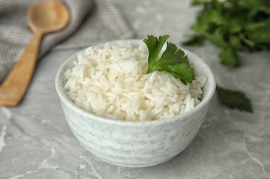 Lezzetli pilav ve maydanozlu kase açık gri mermer masa, yakın plan.